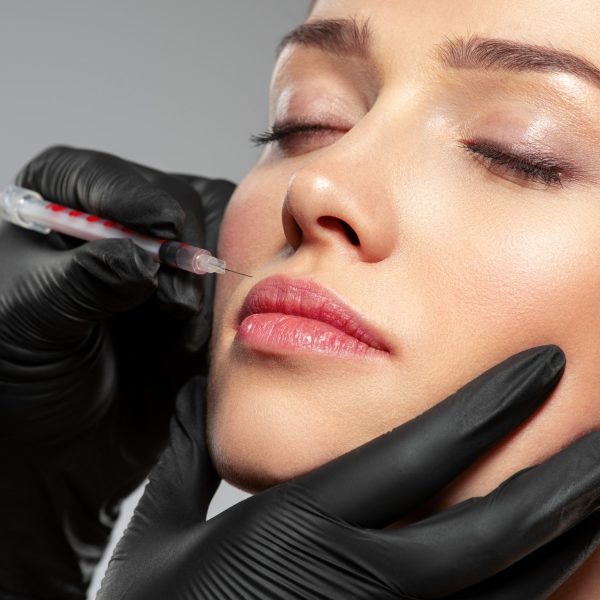 Caucasian woman getting botox cosmetic injection in the lips. Woman gets botox injection in her face